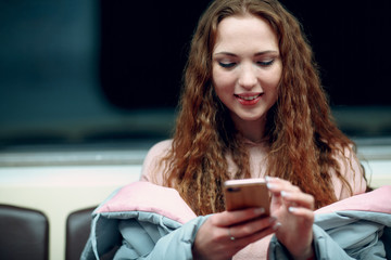 Positive redhead young female typing text message