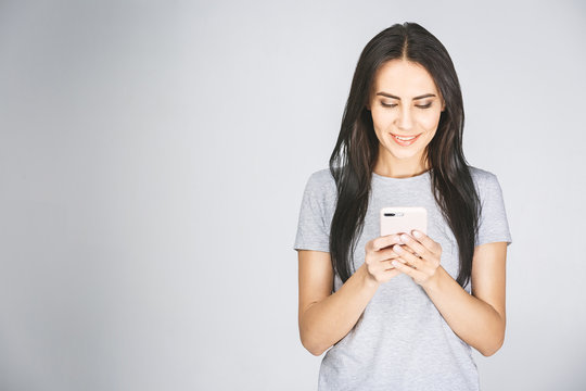 Portrait Of A Happy Young Woman Using Mobile Phone Isolated Over White Background.