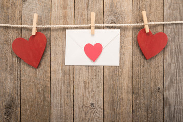  White envelope and red hearts on a rope with pegs 