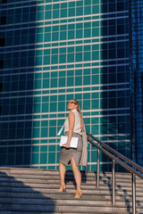 Fototapeta premium Portrait of a young successful business lady in the middle of a business center