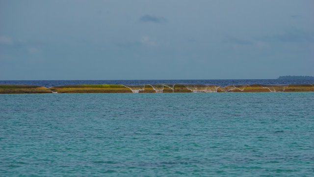 Wellenbrecher am Strand und T&uuml;rkis wasser von Adaaran Select Meedhupparu auf Malediven im Indischer Ozean