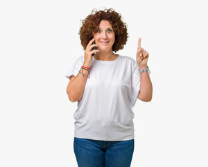 Middle ager senior woman talking on smartphone over isolated background surprised with an idea or question pointing finger with happy face, number one