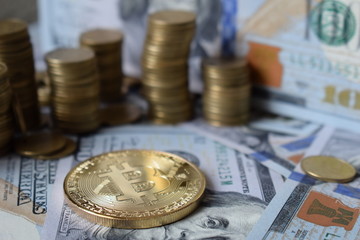 Golden Bitcoins on US dollars. Digital currency close-up. New virtual money. Crypto currency top view. Real coins of bitcoin on banknotes of one hundred dollars. Exchange. Bussiness, commercial.