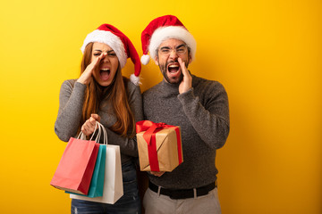 Couple or friends holding gifts and shopping bags shouting something happy to the front