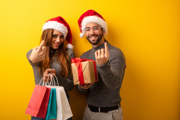 Couple or friends holding gifts and shopping bags inviting to come