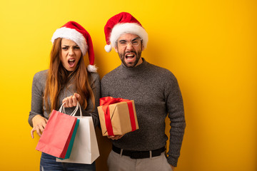 Couple or friends holding gifts and shopping bags screaming very angry and aggressive
