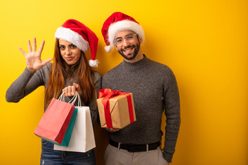 Couple or friends holding gifts and shopping bags showing number five