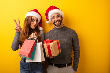 Couple or friends holding gifts and shopping bags showing number two