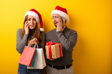 Couple or friends holding gifts and shopping bags desperate and sad