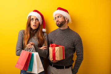 Couple or friends holding gifts and shopping bags tired and bored