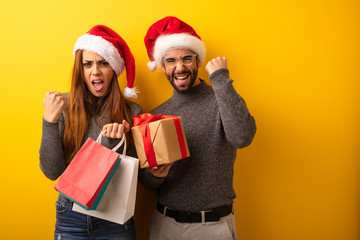 Couple or friends holding gifts and shopping bags surprised and shocked