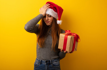 Young pretty woman holding gift forgetful, realize something