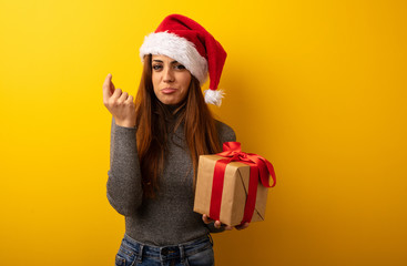 Young pretty woman holding gift doing a gesture of need
