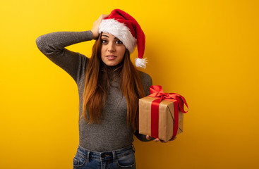 Young pretty woman holding gift worried and overwhelmed