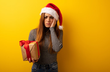 Young pretty woman holding gift desperate and sad