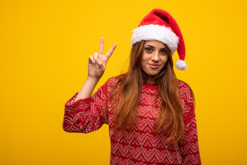 Young woman wearing santa hat fun and happy doing a gesture of victory