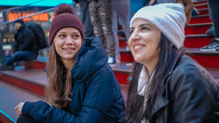 Two girls sit on famous Father Duffy steps at Times Square New York