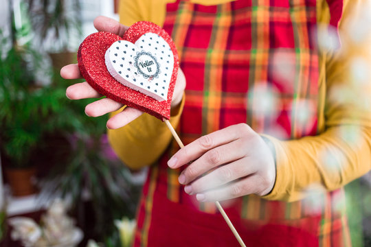 Saleswoman holds beautiful heart stick "Volim te" writing on it. Beautiful gift for Valentine's day