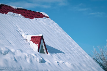 Snow-covered roof red metal tile