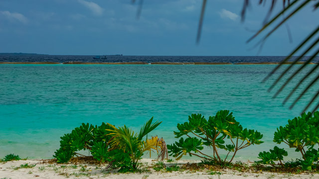 Strand mit Wellenbrecher mit T&uuml;rkis wasser von Adaaran Select Meedhupparu auf Malediven im Indischer Ozean