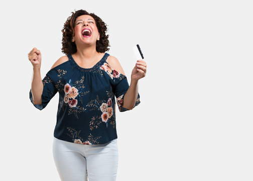 Middle Aged Woman Cheerful And Smiling, Very Excited Holding The New Bank Card, Ready To Go Shopping