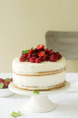 Summer home biscuit cake with curd cream, decorated with fresh berries of strawberries, raspberries and currants.