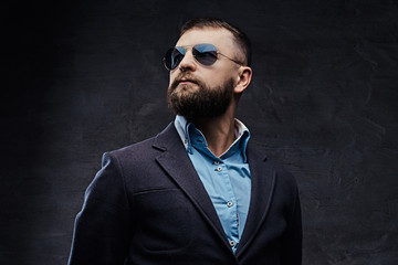 Studio portrait of a successful businessman wearing a suit and sunglasses