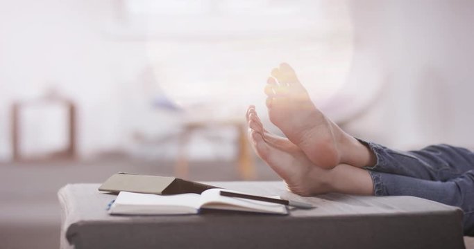 Young women relaxing barefoot in her home office