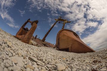 Old rusty wreck and rocky beach in Baltic Sea, natural environment. Osmussaar, Estonia, Europe.