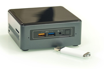 Single-board personal miniature computer with USB flash drive isolated on white.