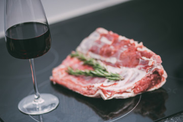 Raw pork ribs with a glass of red wine