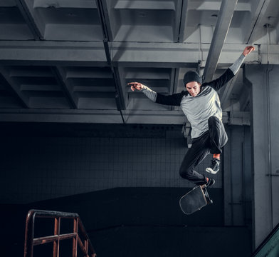 Skateboarder jumping high on mini ramp at skate park indoor.