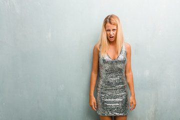 Portrait of young elegant blonde woman very angry and upset, very tense, screaming furious, negative and crazy