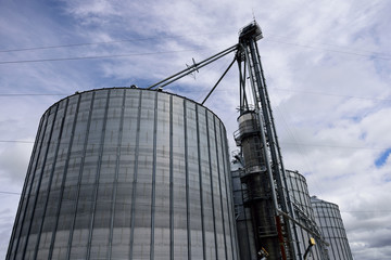 Several massive agricultural steel grain storage silos used for farming in rural far North Texas, USA