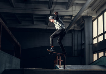 Skateboarder performing a trick on mini ramp at skate park indoor.