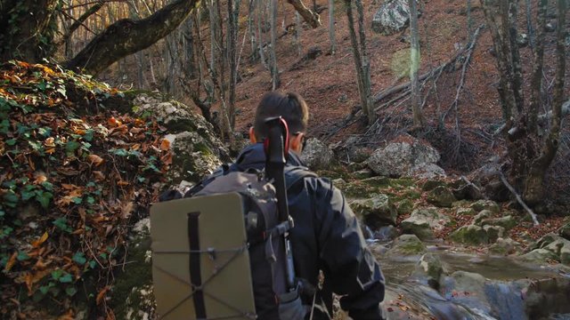 Hiker is crossing the river 4K