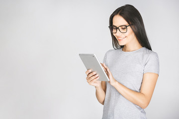 Fototapeta premium Portrait with copy space empty place of pretty charming confident smiling woman in casual having tablet in hands isolated on white background.