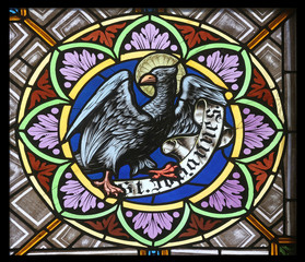 Symbols of the Saint John the Evangelist, stained glass window in the parish church of St. Peter and Paul in Oberstaufen, Germany 