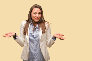 Caucasian business young woman doubting and shrugging shoulders