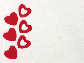 red felt hearts on white paper background with space for text