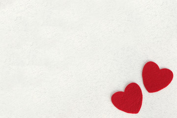 red felt hearts on white paper background with space for text