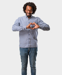 Handsome business african american man making a heart with hands, expressing the concept of love and friendship, happy and smiling