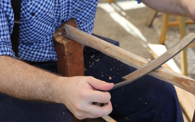 carpenter uses an old planer to plan the wood