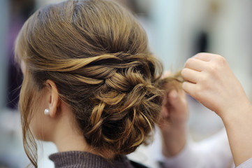 Young woman/bride getting her hair done before wedding or party