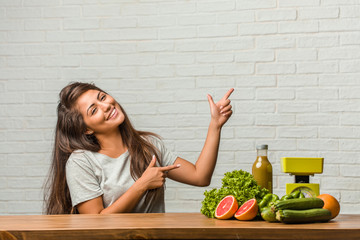Concept of diet. Portrait of a healthy young latin woman pointing to the side, smiling surprised presenting something, natural and casual