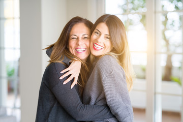 Beautiful family of mother and daughter together, hugging and kissing at home