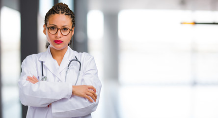 Portrait of a young black doctor woman very angry and upset, very tense, screaming furious,...