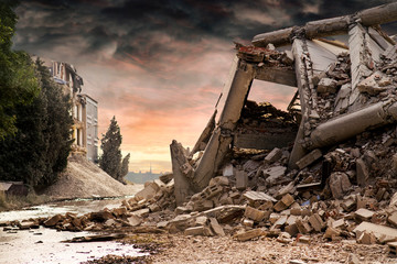 View on a collapsed concrete industrial building with dark red dramatic sky above. Damaged house...
