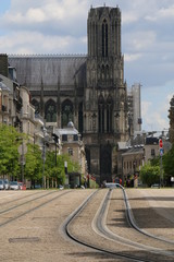 Fototapeta na wymiar Street, tram track in the center of Reims. Cathedral in the background. Spring in the city. France. Marne. Champagne-Ardenne.