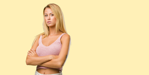 Fototapeta premium Portrait of young pretty blonde woman crossing his arms, serious and imposing, feeling confident and showing power